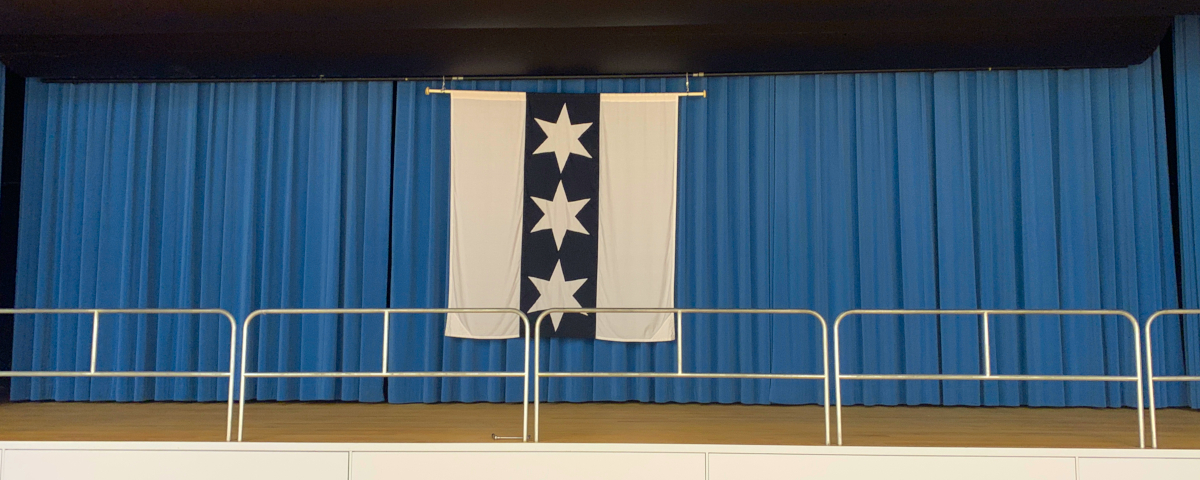 Binninger Flagge hängt vor einem blauen Vorhang.